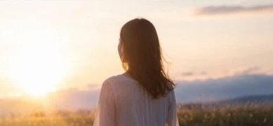 夕日の草原に立つ人